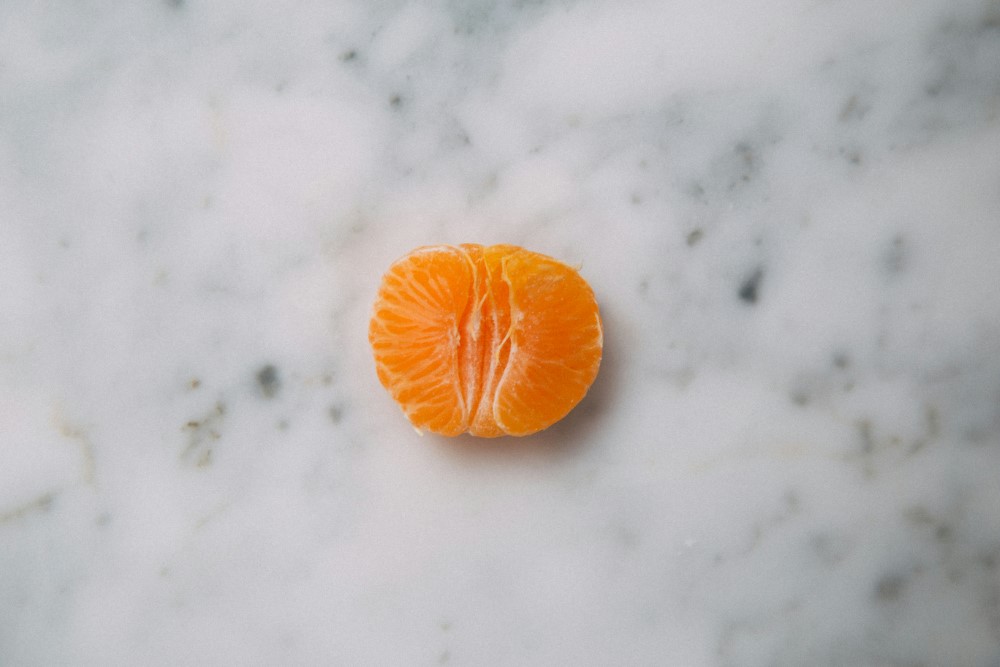 half a mandarin orange on marble countertop