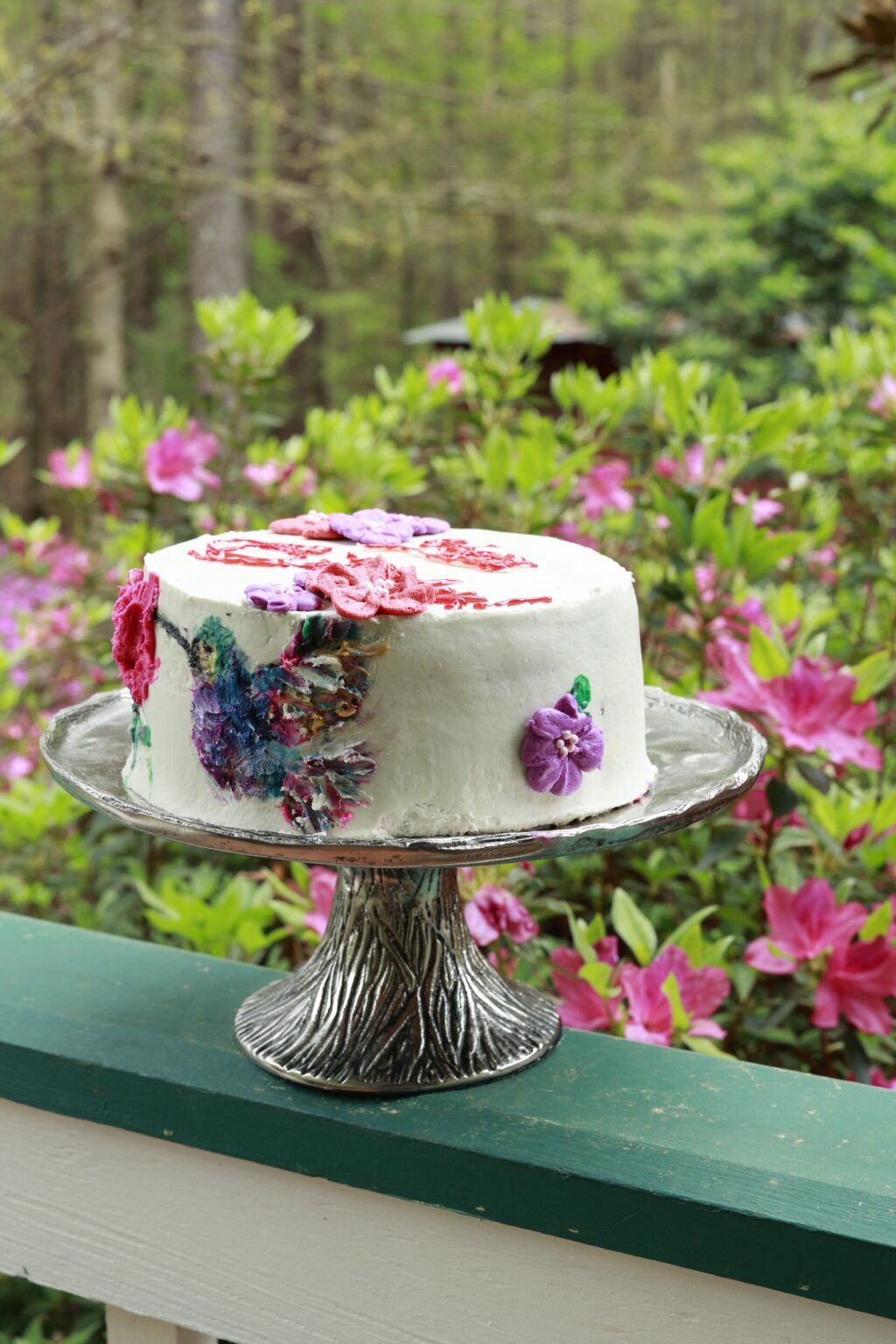 hummingbird cake decorated with frosting hummingbird, flowers, and Happy Birthday message