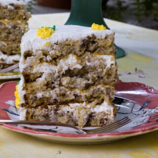 slice of 3-layer hummingbird cake on pink dessert plate with fork