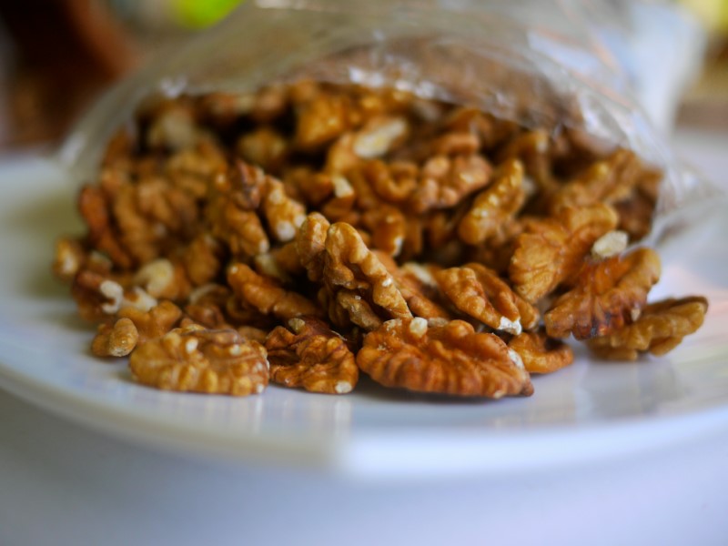 pecan halves spilling from clear bag onto white plate
