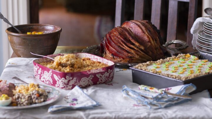 vertical photo of Easter table with southern glazed ham, casserole, and other dishes