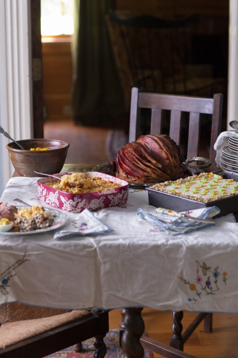 vertical photo of Easter table with southern glazed ham, casserole, and other dishes
