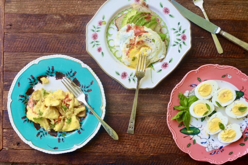 eggs 3 ways - scrambled, fried, and hard boiled - on different colored plates