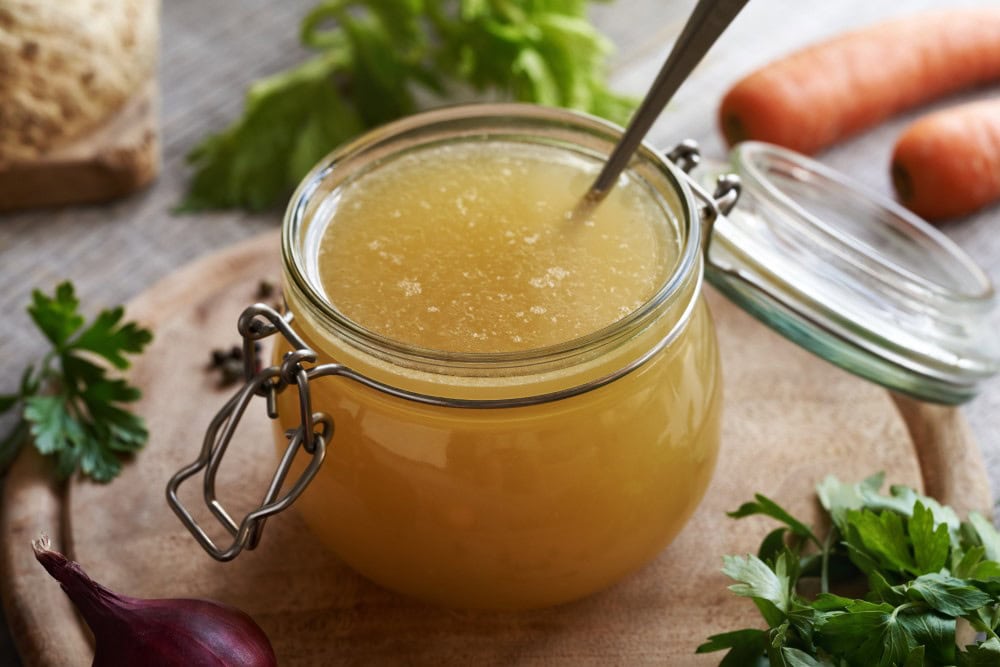Chicken stock or chicken bone broth in glass jar