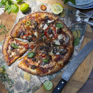 Stacy Lyn's Domino's style pizza loaded with toppings and sliced on cutting board