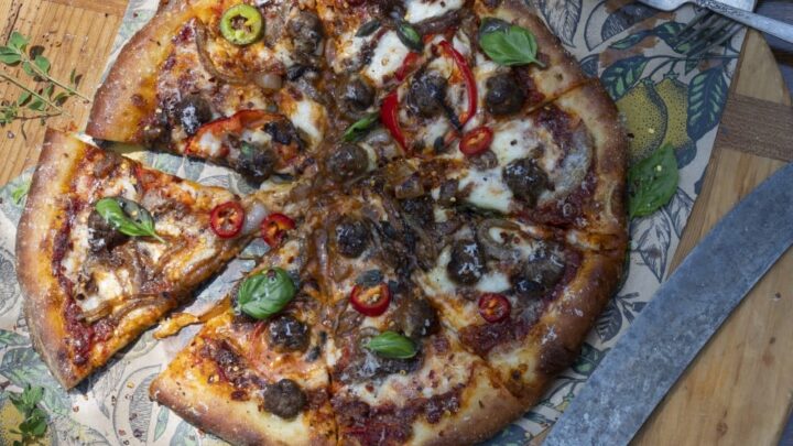 Stacy Lyn's Domino's style pizza loaded with toppings and sliced on cutting board