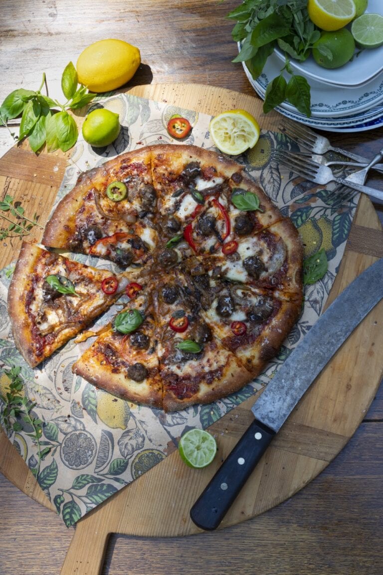 Stacy Lyn's Domino's style pizza loaded with toppings and sliced on cutting board