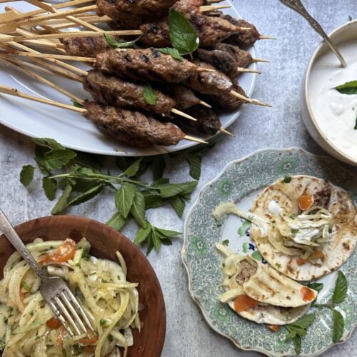 adana / kofta kebabs on skewers, served with onion salad and