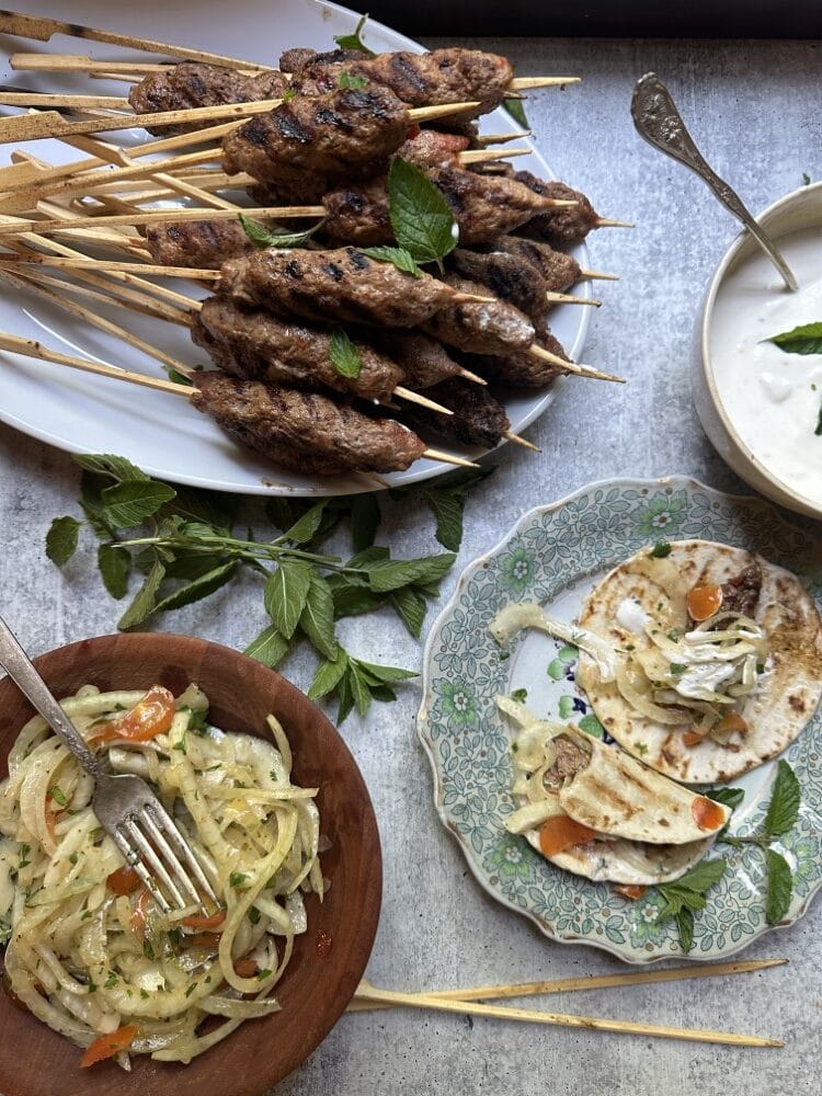 adana / kofta kebabs on skewers, served with onion salad and
