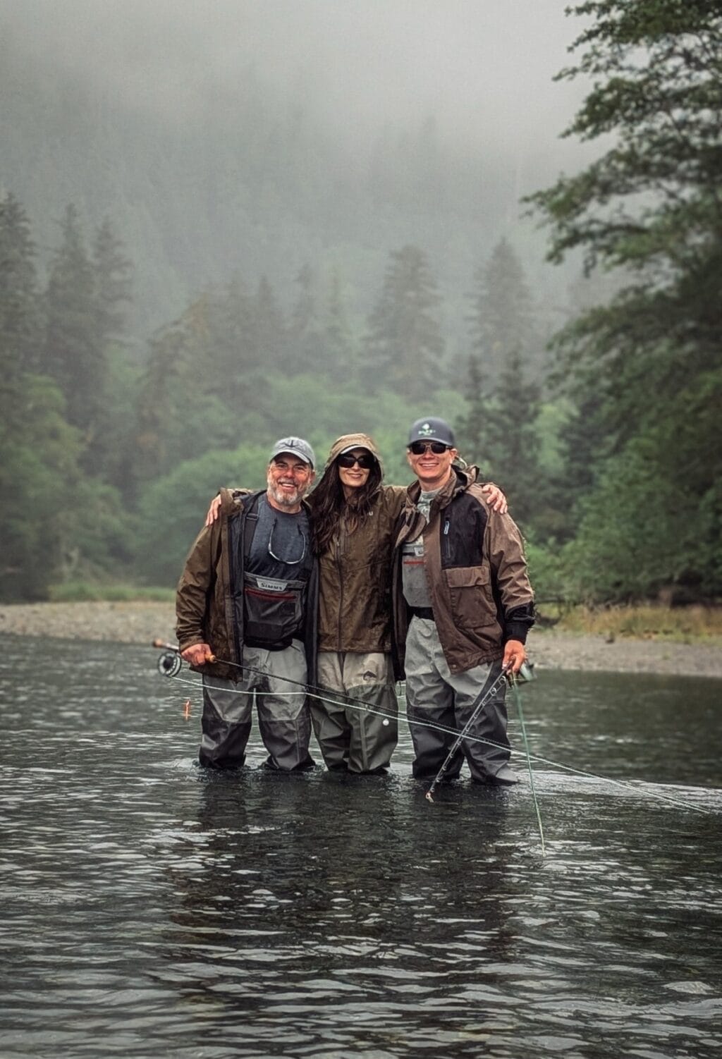 Scott, Stacy Lyn, and Howlett standing in Alaska river fly fishing  in a river near Sitka Alaska