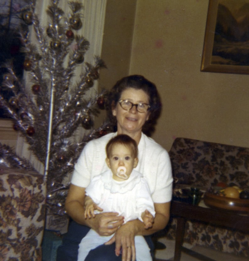 Stacy Lyn as a baby on her Granny Gray's lap in the living room with Christmas tree in background