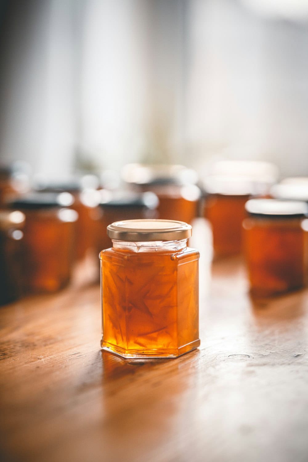 small glass jars full of orange marmalade