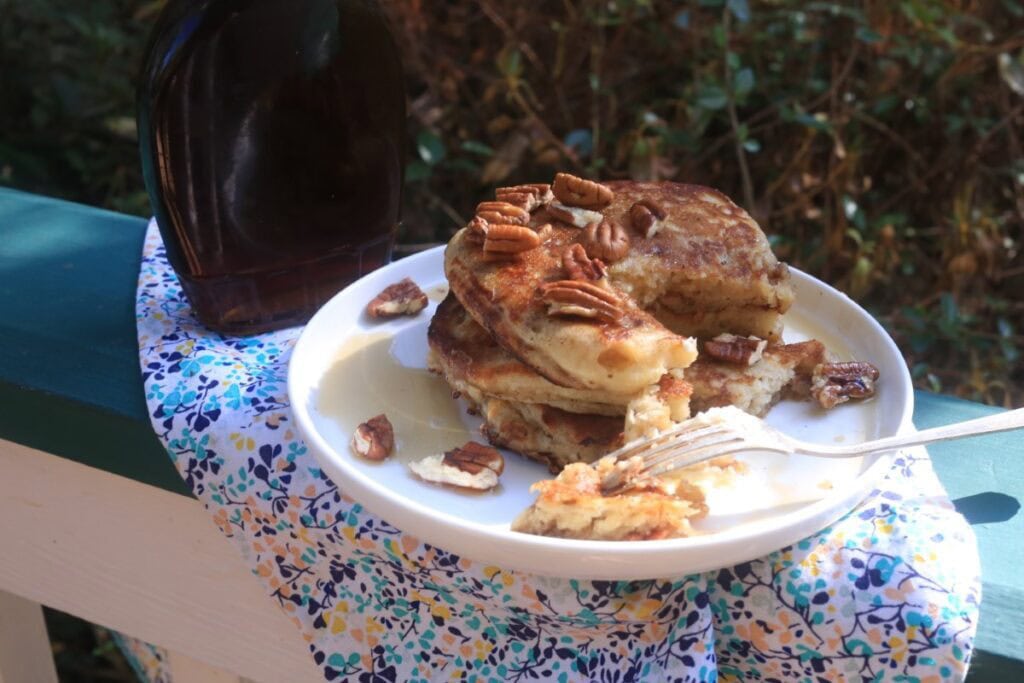 inviting stack of pecan pancakes on porch railing over floral napkin