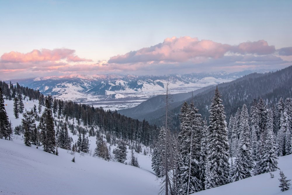 wide view of winter tree line, mountains, and clouds in Jackson Hole, Wyoming