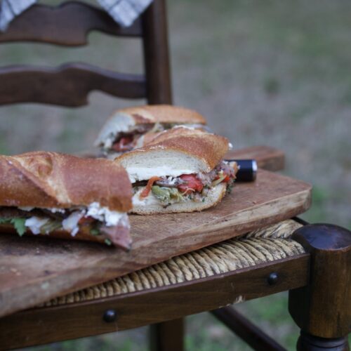 venison steak sandwich on cutting board on chair outside