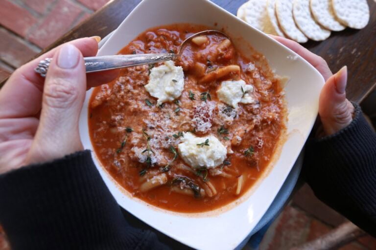 Lasagna Soup in square white bowl held by Stacy Lyn Harris