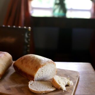 sliced loaf of sourdough bread on wood cutting board