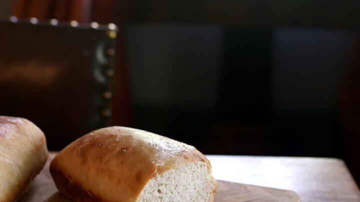 sliced loaf of sourdough bread on wood cutting board