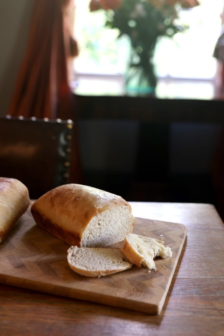 sliced loaf of sourdough bread on wood cutting board