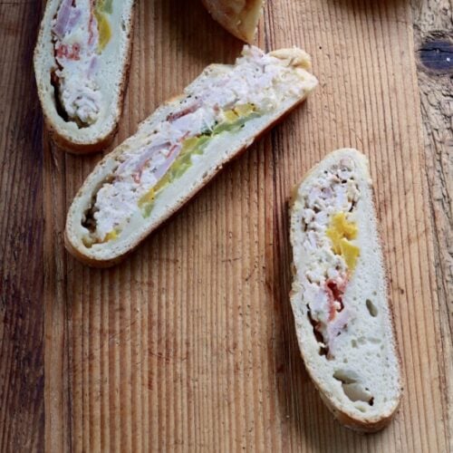slices of picnic sandwich, inspired by stromboli and calzone recipes, on wood table