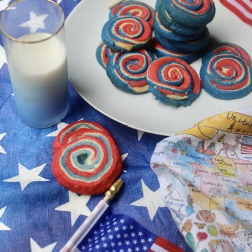 Colorful patriotic pinwheel cookies with American flags and milk for Independence Day.