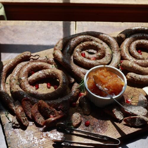 homemade pork sausage on cutting board with jam