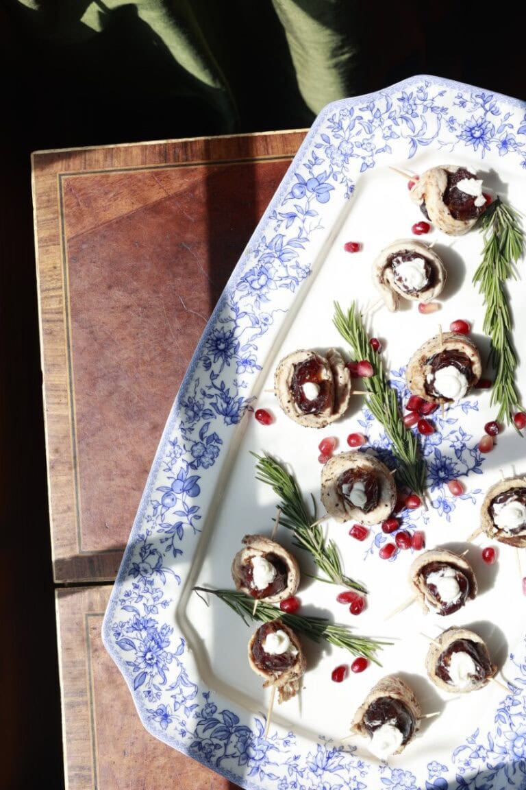 turkey, cheese, and date roll ups arranged on platter with sprigs of rosemary
